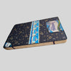 Black tufted bed with white bedding and 'Universal Mattresses' logo on a light gray background

