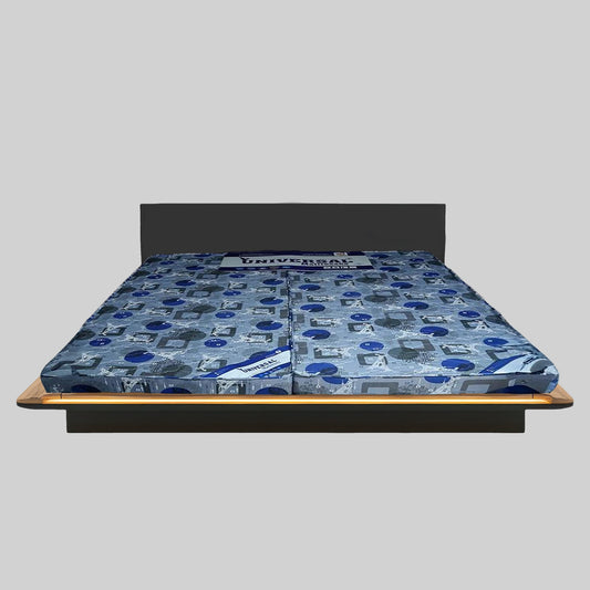 Blue patterned mattress on a bed frame against a gray background