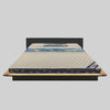 Mattress on a wooden bed frame with a gray background